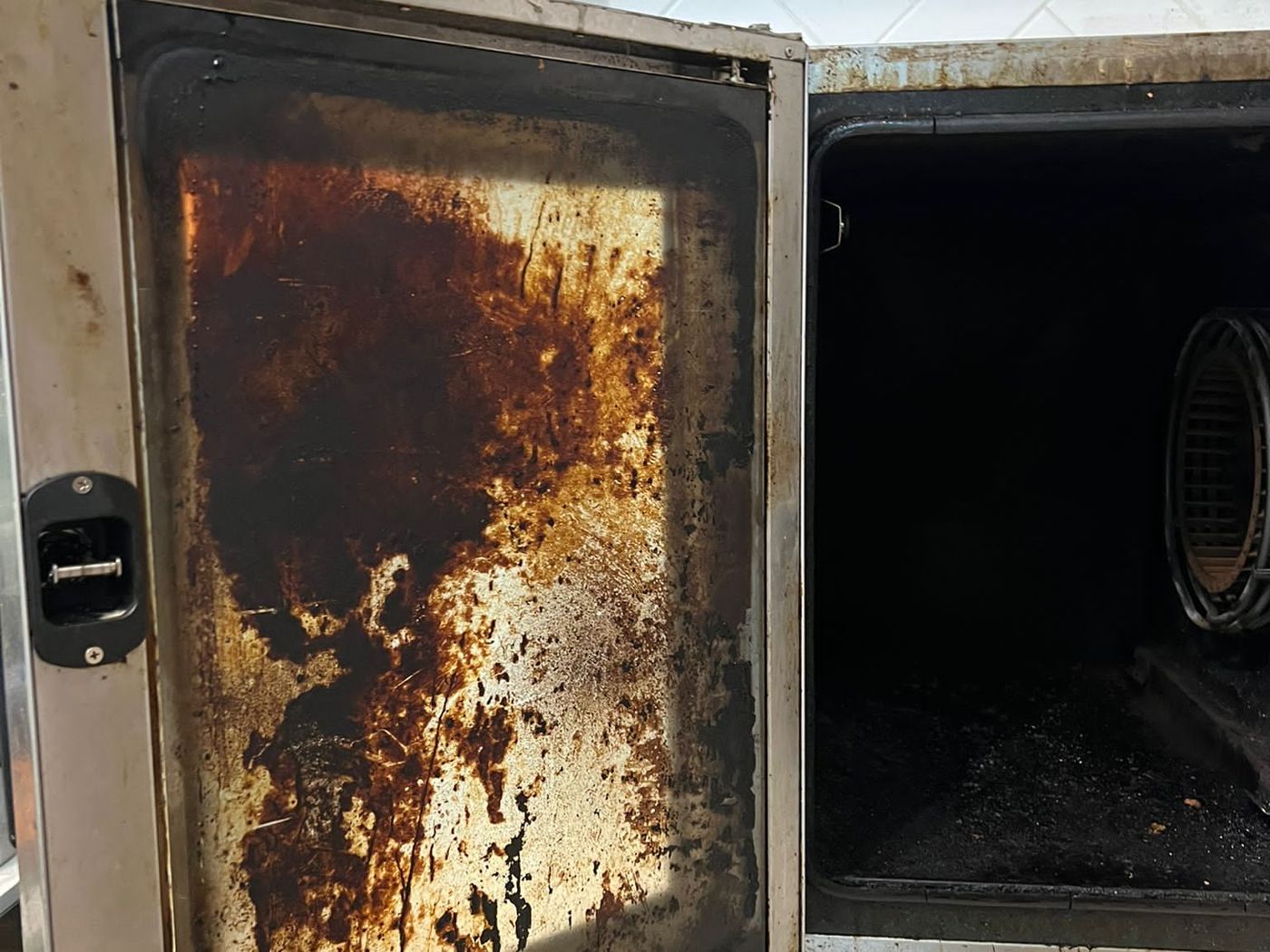 Combi oven door caked in grime before cleaning
