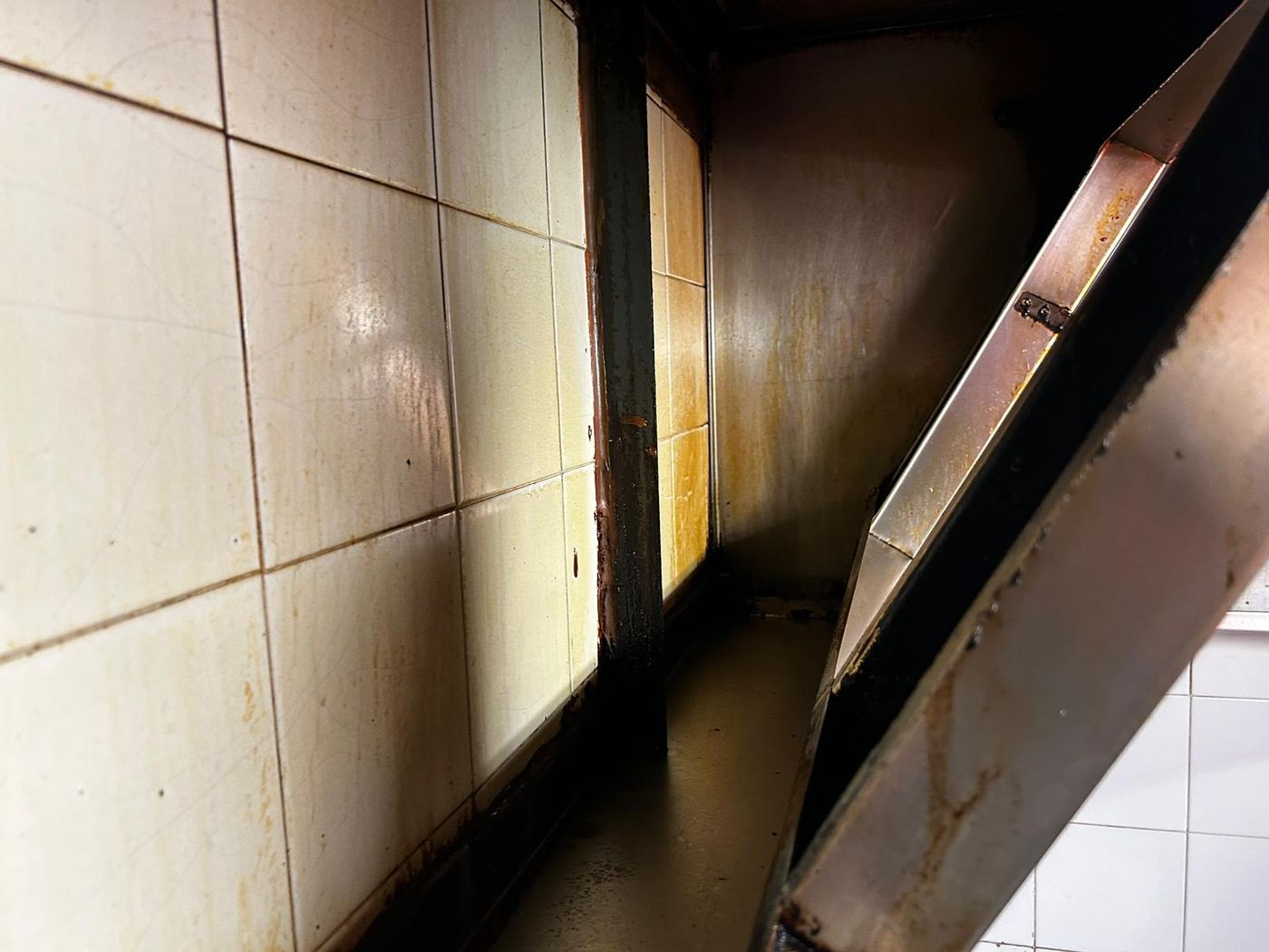 Grease-stained tiles behind the canopy before cleaning